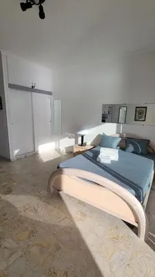 a bedroom with a bed in a white room at La plage à vos pieds, magnifique vue sur Ajaccio, pour 2 personnes in Ajaccio