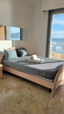 a bed with towels on it in a room with a window at La plage à vos pieds, magnifique vue sur Ajaccio, pour 2 personnes in Ajaccio