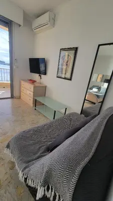 a bedroom with a bed and a desk and a television at La plage à vos pieds, magnifique vue sur Ajaccio, pour 2 personnes in Ajaccio