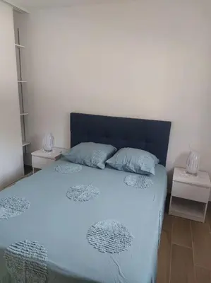 a bedroom with a blue bed with two pillows at Maison avec piscine, à proximité des plages in Porto-Vecchio