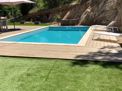 a swimming pool in a yard with a table and an umbrella at Maison avec piscine, à proximité des plages in Porto-Vecchio