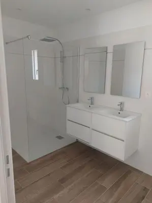 a white bathroom with two sinks and mirrors at Maison avec piscine, à proximité des plages in Porto-Vecchio