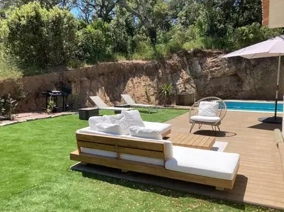 a patio with chairs and an umbrella and a pool at Maison avec piscine, à proximité des plages in Porto-Vecchio