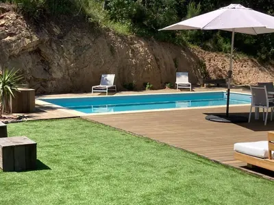 a swimming pool with two chairs and an umbrella at Maison avec piscine, à proximité des plages in Porto-Vecchio