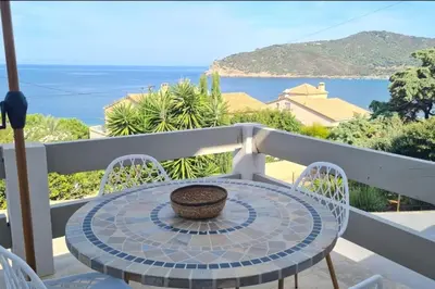 a table and chairs on a balcony with an umbrella at Apartment with balcony and 360 sea view in Villanova