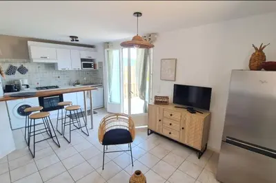 a kitchen with a refrigerator and some bar stools at Apartment with balcony and 360 sea view in Villanova