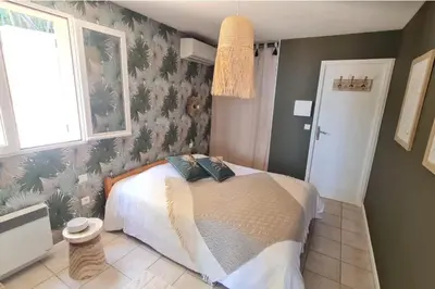 a bedroom with a bed with a tropical wallpaper at Apartment with balcony and 360 sea view in Villanova