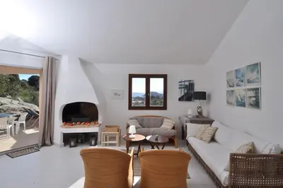 a living room with a couch and a fireplace at Sea view villa - Cala Rossa private park in Lecci