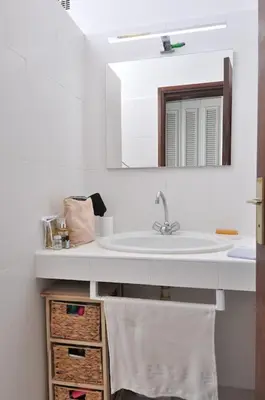 a bathroom with a sink and a mirror at Sea view villa - Cala Rossa private park in Lecci