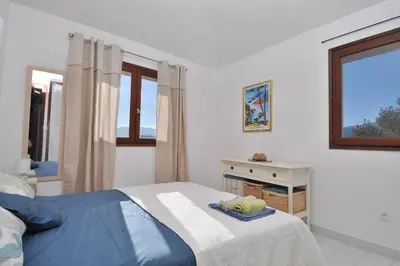 a white bedroom with a bed and a window at Sea view villa - Cala Rossa private park in Lecci