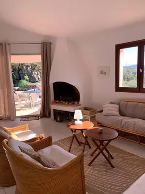 a living room with a couch and a fireplace at Sea view villa - Cala Rossa private park in Lecci