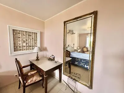 a room with a desk and a mirror and a bed at Maison Les aloes - vue mer et proche centre ville in Propriano
