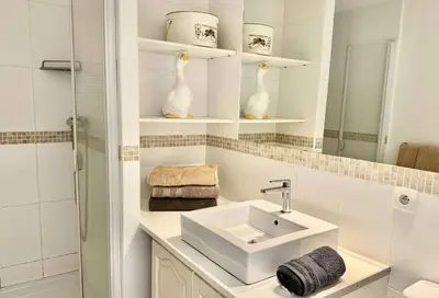 a white bathroom with a sink and a mirror at Maison Les aloes - vue mer et proche centre ville in Propriano