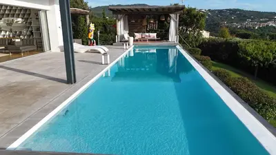 a swimming pool with blue water in a backyard at Giulia, villa exceptionnelle, vue mer et Ajaccio in Porticcio