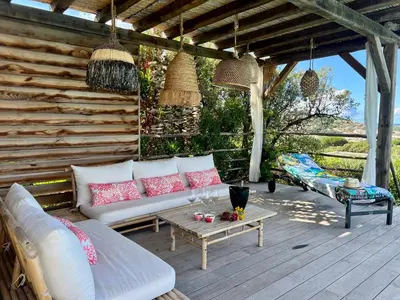 a patio with a white couch and a table at Giulia, villa exceptionnelle, vue mer et Ajaccio in Porticcio