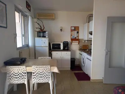 a kitchen with a table and chairs and a refrigerator at t1 bis vue imprenable in Ajaccio