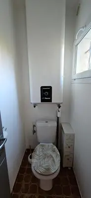 a small bathroom with a toilet with a microwave above it at T3 Paradisiaque sur la plage, les pieds dans l'eau in Olmeto