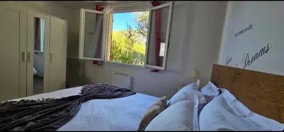 a bedroom with a bed and a window at T3 Paradisiaque sur la plage, les pieds dans l'eau in Olmeto