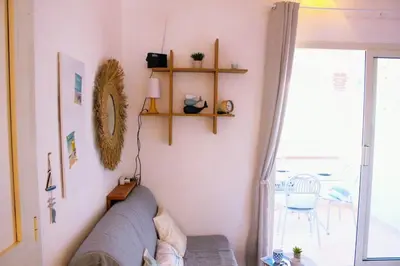 a living room with a couch and shelves on the wall at Charmant appartement climatisé proche mer in Linguizzetta