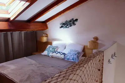 a bedroom with a bed with pillows on it at Charmant appartement climatisé proche mer in Linguizzetta