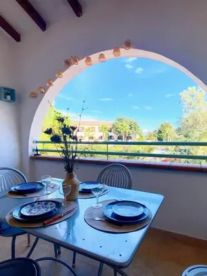 a blue table with chairs and a large window at Charmant appartement climatisé proche mer in Linguizzetta