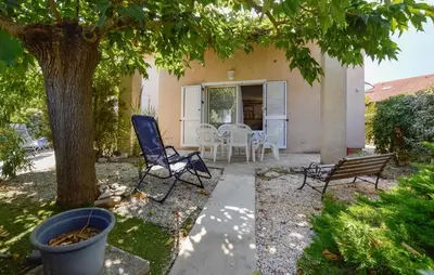 a patio with chairs and a table under a tree at Beautiful Home In Cervione With Wifi in Cervione