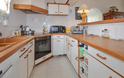 a kitchen with white cabinets and a wooden counter top at Beautiful Home In Cervione With Wifi in Cervione