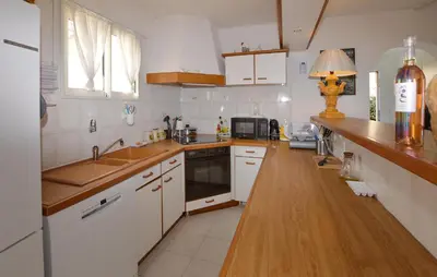 a kitchen with white cabinets and a wooden counter top at Beautiful Home In Cervione With Wifi in Cervione