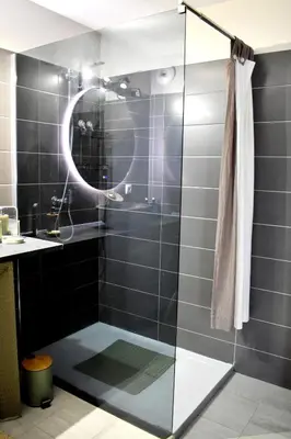 a bathroom with a shower with a sink and a mirror at Studio Terrasse entre ville et port in Porto-Vecchio