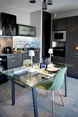 a kitchen with a glass table and some chairs at Studio Terrasse entre ville et port in Porto-Vecchio