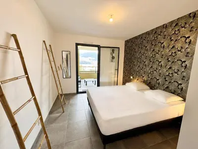 a bedroom with a bed and a stone wall at T2 moderne avec vue mer et proche centre-ville in Propriano