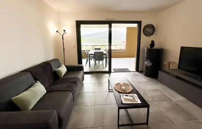 a living room with a couch and a table at T2 moderne avec vue mer et proche centre-ville in Propriano