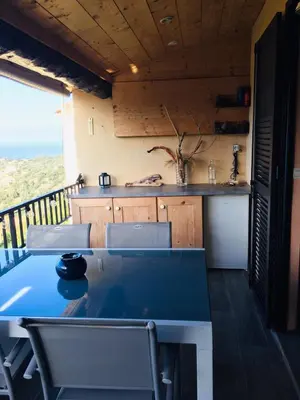 a table and chairs in a room with a kitchen at APT 2 chambres vue exceptionnelle in Tiuccia