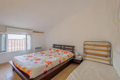 a bedroom with a bed and a window at Jaso - Maison à 5min de la plage in Cervione