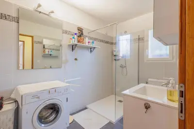 a bathroom with a washing machine and a sink at Jaso - Maison à 5min de la plage in Cervione