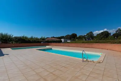 a swimming pool on a tiled floor next to a brick wall at Jaso - Maison à 5min de la plage in Cervione