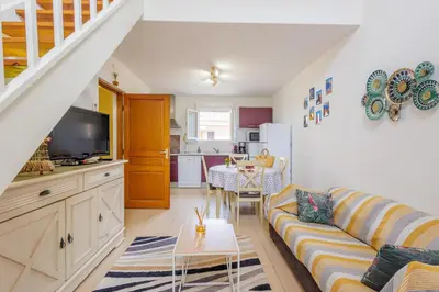 a living room with a couch and a kitchen at Jaso - Maison à 5min de la plage in Cervione