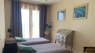 a bedroom with two beds and a dresser and a window at Chambre Mustang avec piscine Villa CasaEva in Porto-Vecchio