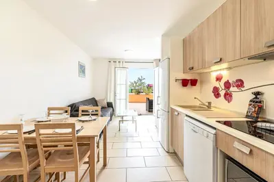 a kitchen and living room with a table and chairs at La Marina - Appt climatisé pour 4 in Sari Solenzara