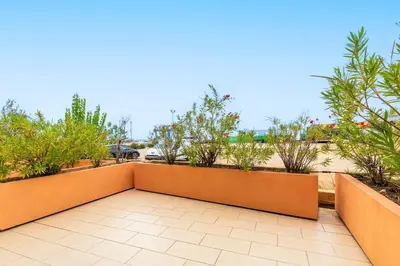 a balcony with orange walls and trees and plants at La Marina - Appt climatisé pour 4 in Sari Solenzara