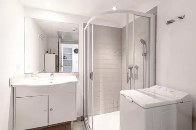 a white bathroom with a sink and a shower at La Marina - Appt climatisé pour 4 in Sari Solenzara