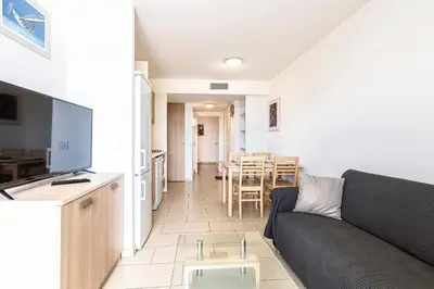 a living room with a couch and a table at La Marina - Appt climatisé pour 4 in Sari Solenzara