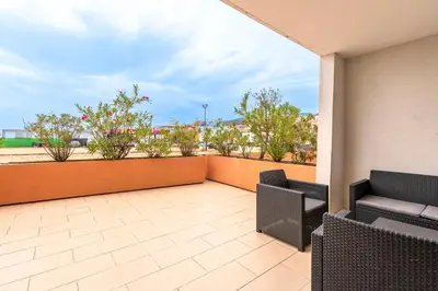 a balcony with two chairs and a patio at La Marina - Appt climatisé pour 4 in Sari Solenzara