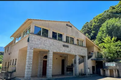 an old stone building with a mountain in the background at Gîte de randonneurs Bocca bè in Chisa