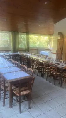 a dining room with tables and chairs and windows at Gîte de randonneurs Bocca bè in Chisa
