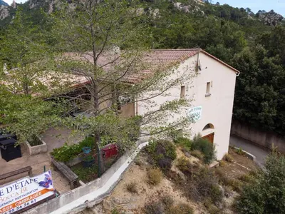 a house on a hill with a tree in front of it at Gîte de randonneurs Bocca bè in Chisa