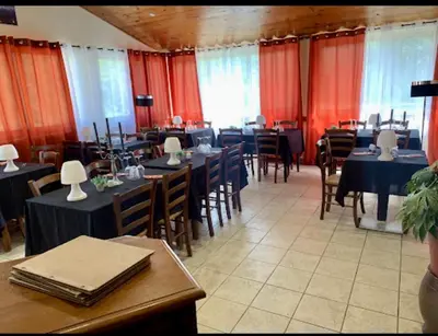 a dining room with tables and chairs and red curtains at Gîte de randonneurs Bocca bè in Chisa