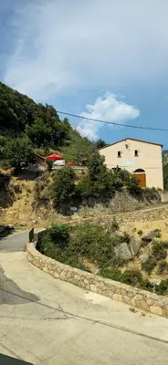 a house on the side of a hill with a road at Gîte de randonneurs Bocca bè in Chisa