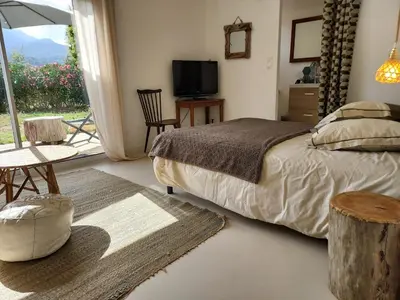 a bedroom with a bed and a tv and a window at Suite indépendante avec vue in Sarrola-Carcopino