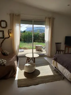 a bedroom with a bed and a table in front of a window at Suite indépendante avec vue in Sarrola-Carcopino